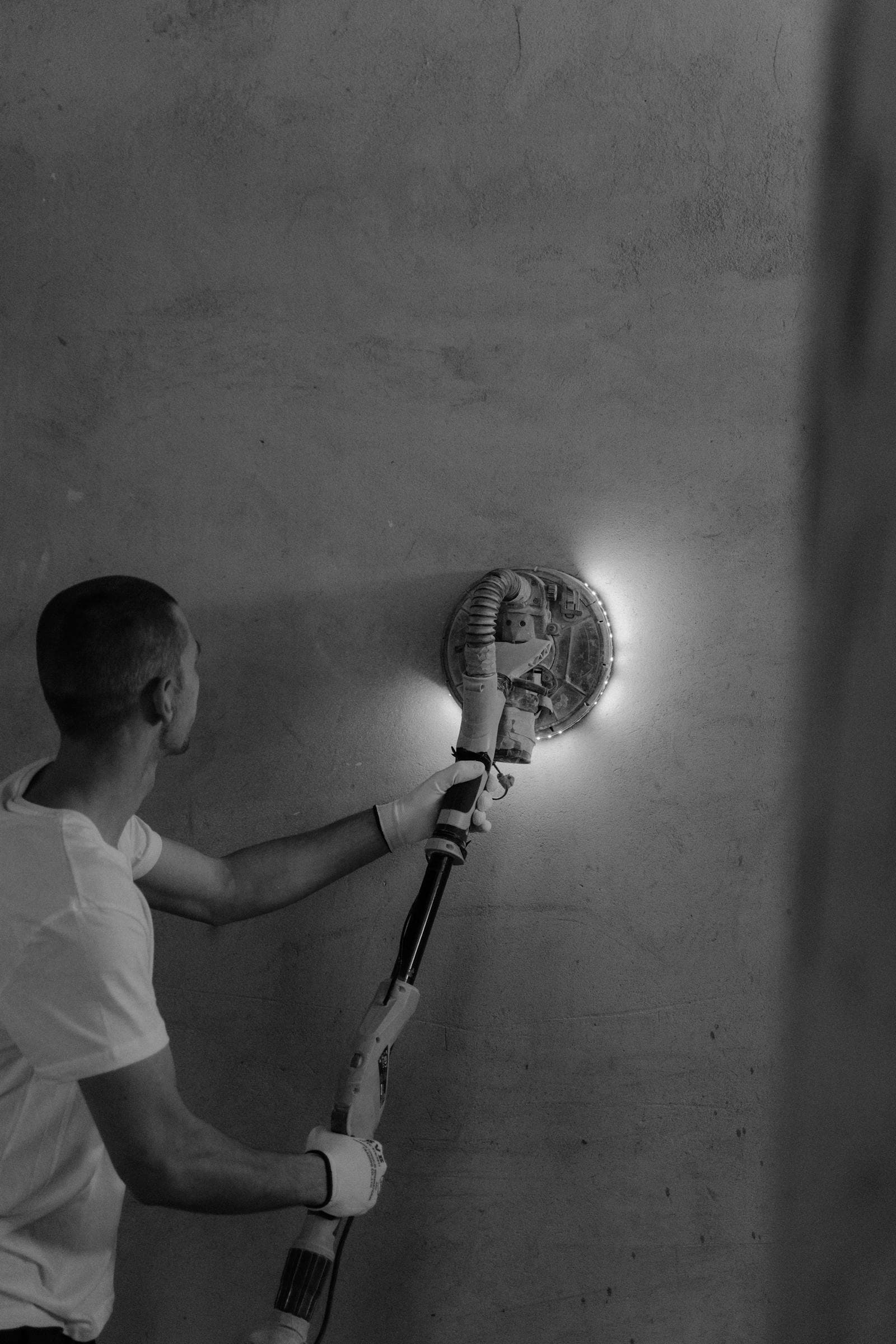 Maintenance worker repairing an interior property wall